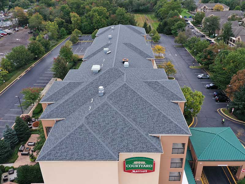 Top view of a Marriott Courtyard hotel with newly installed gray asphalt shingles on its roof