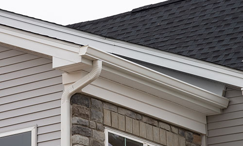 Close up of a white k-style gutter system on the fascia of a home
